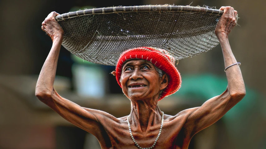 a woman wearing a red hat, holding a tray with beads on it