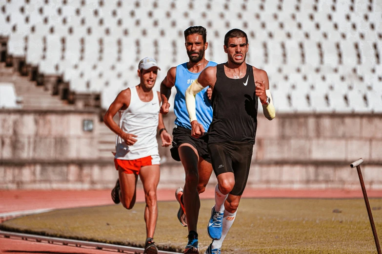 three men are running around on a track