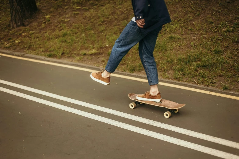 a person is walking on a skate board on the side of the road