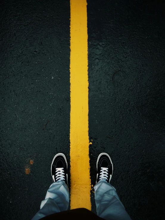 the top of a man's shoe, in front of a yellow line