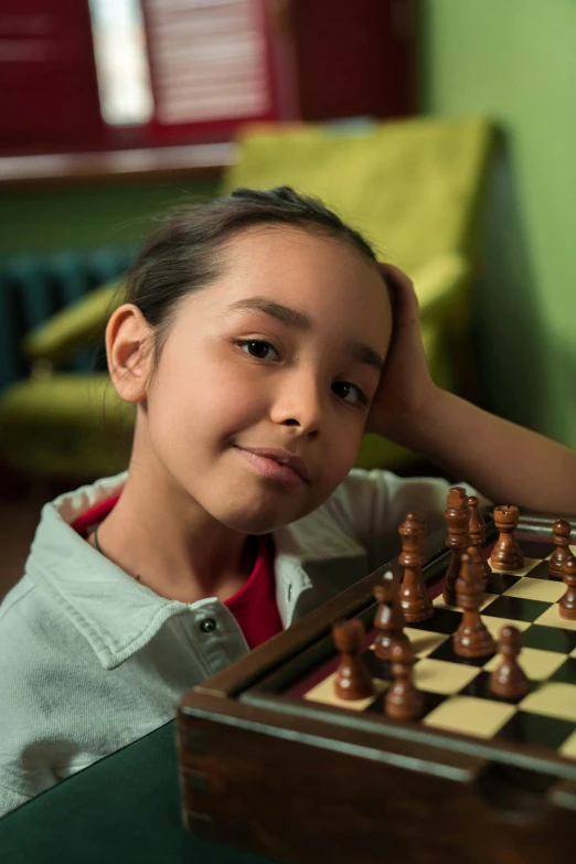 a young person posing next to a large chess board