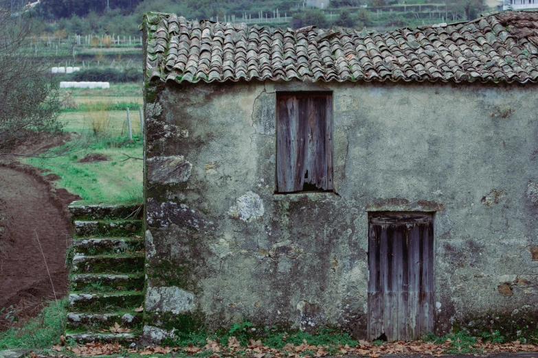 an old house with a stone chimney and stairs leading up to the doorway