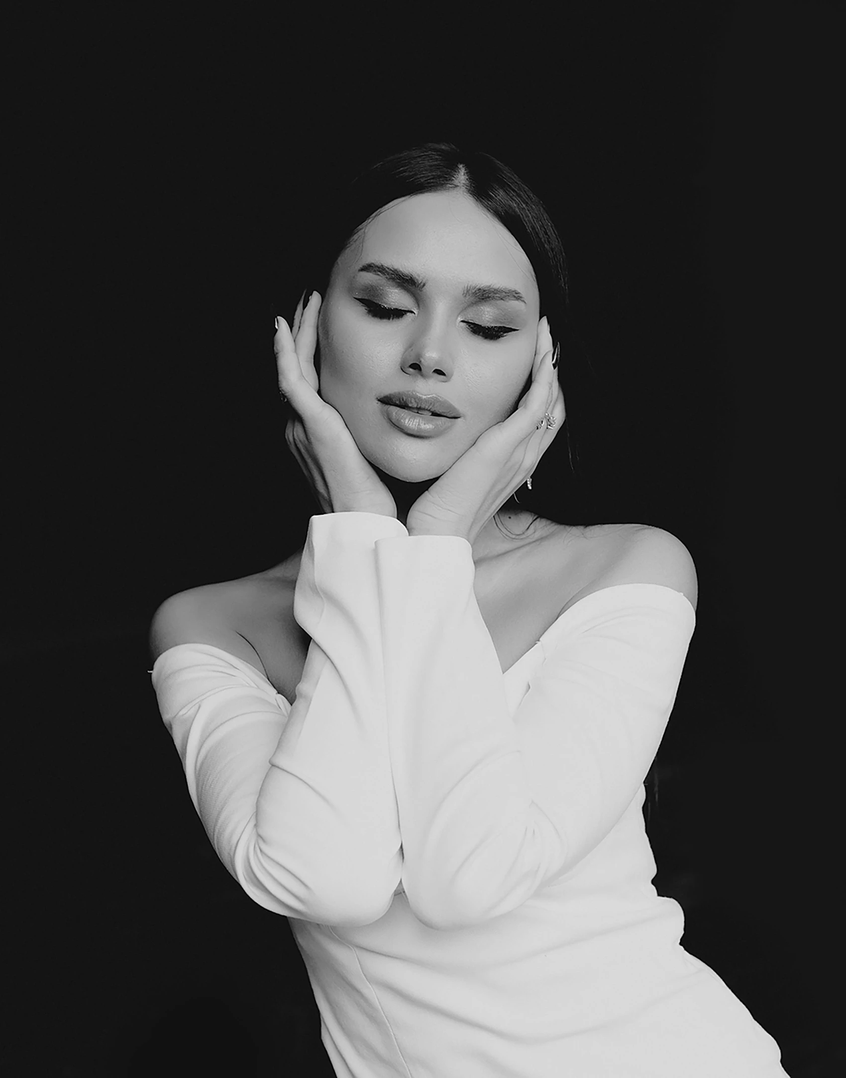 woman in white dress posing with arms crossed over her face