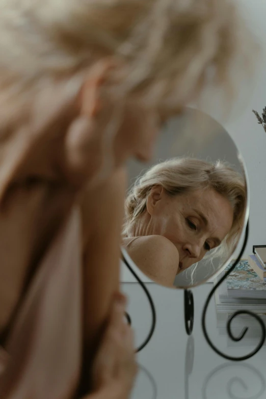 a woman looking at herself in the mirror