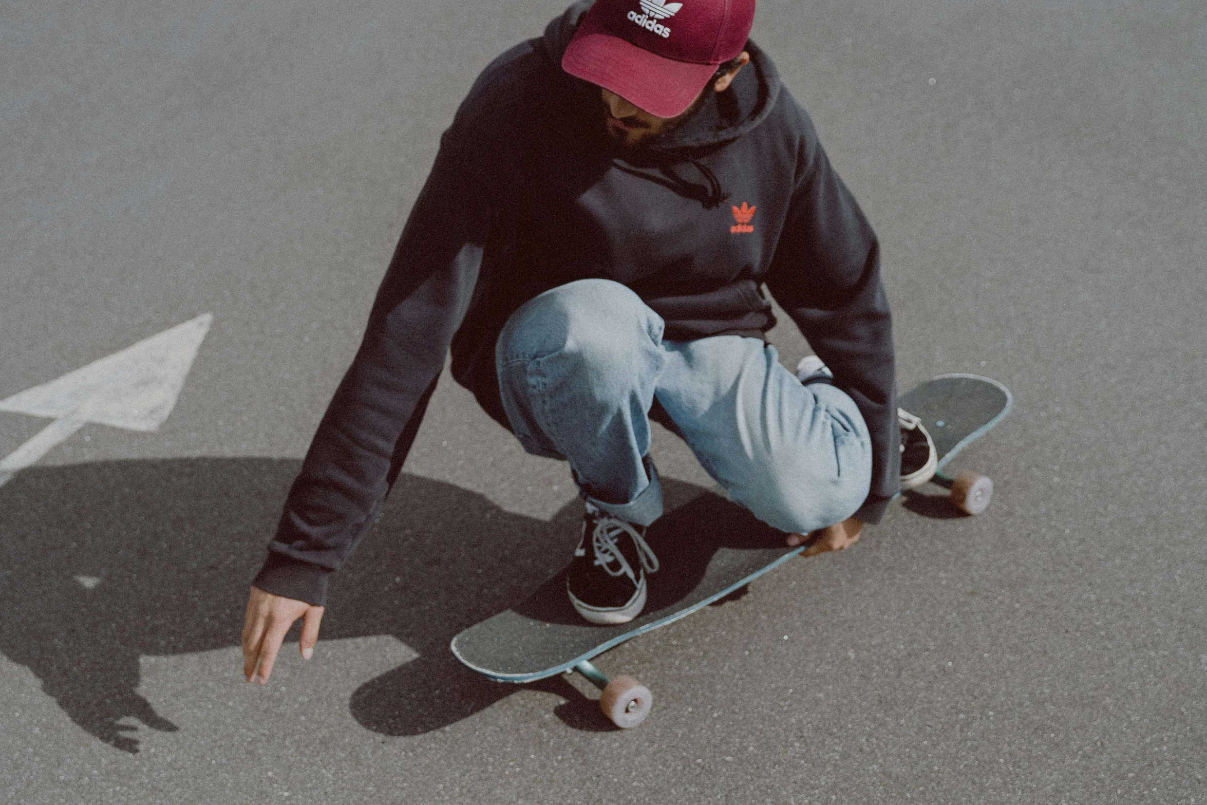 a skateboarder sitting on the floor, doing a trick