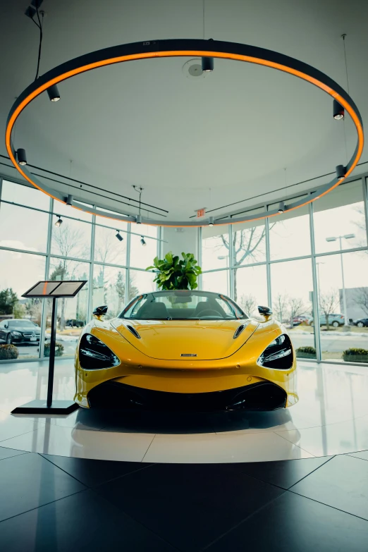 a yellow sports car in a building with large windows