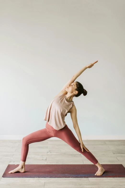 a woman in a yoga pose with her arms outstretched