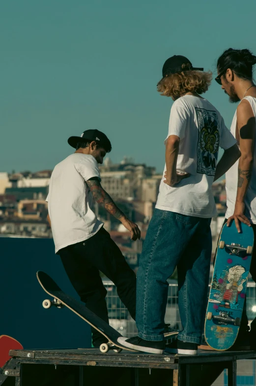 three guys standing on a ramp holding skateboards