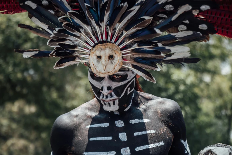 a man is dressed up like a native american indian warrior