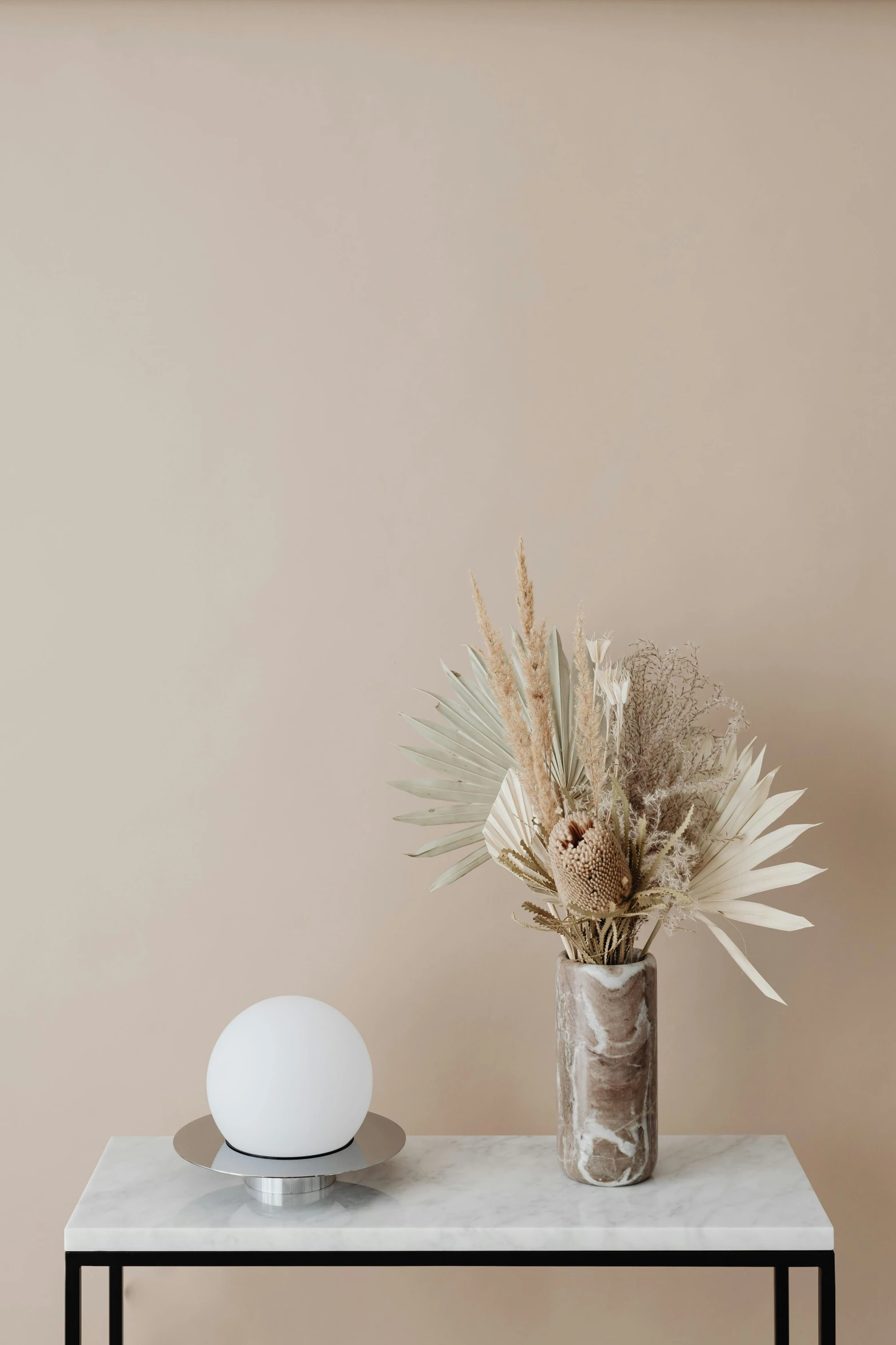 the vase on top of the table has a white sphere