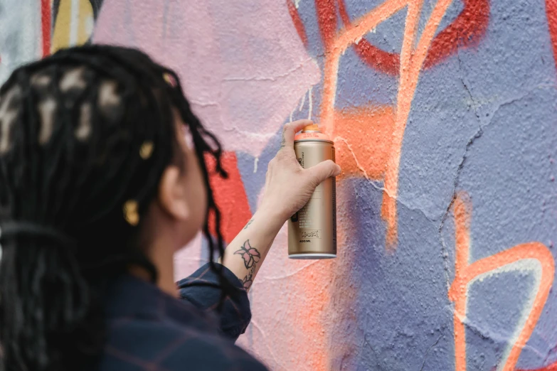 a woman using a spray can to paint graffiti