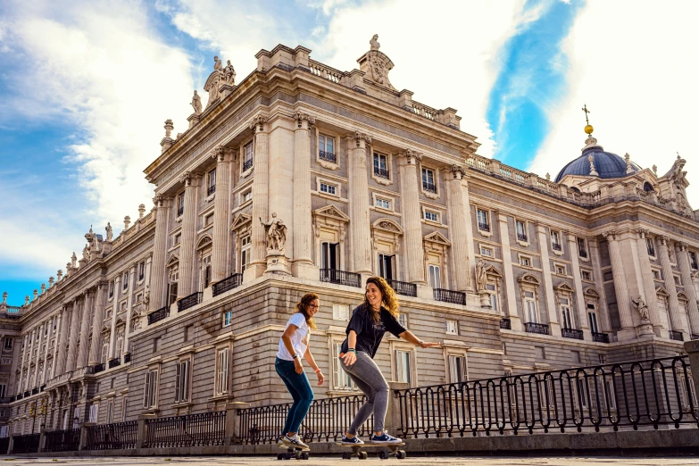 two people are riding skateboards in front of a building