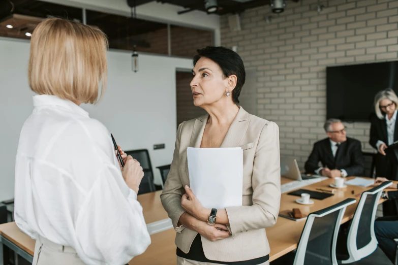 a woman in an office talking to someone while talking to another person