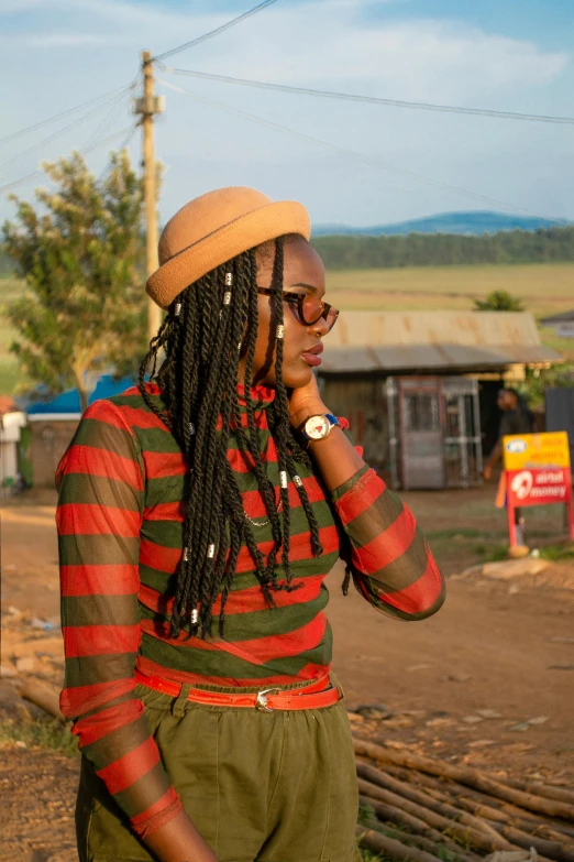 woman with dreadlocks on her face while talking on a phone