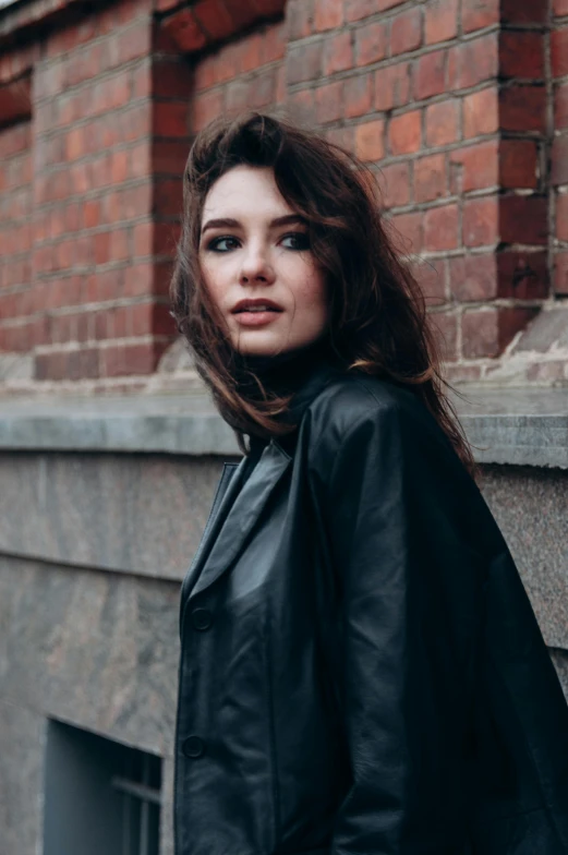 a woman leaning on the corner near a wall