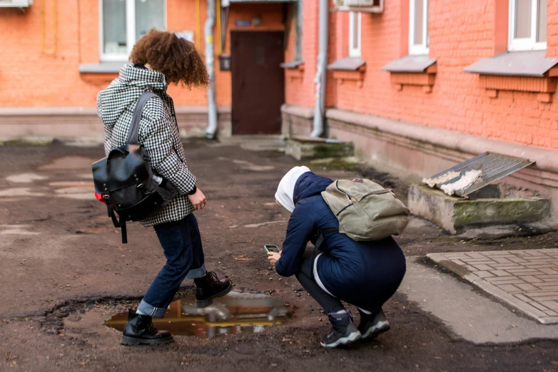 two people in front of some buildings with their bags