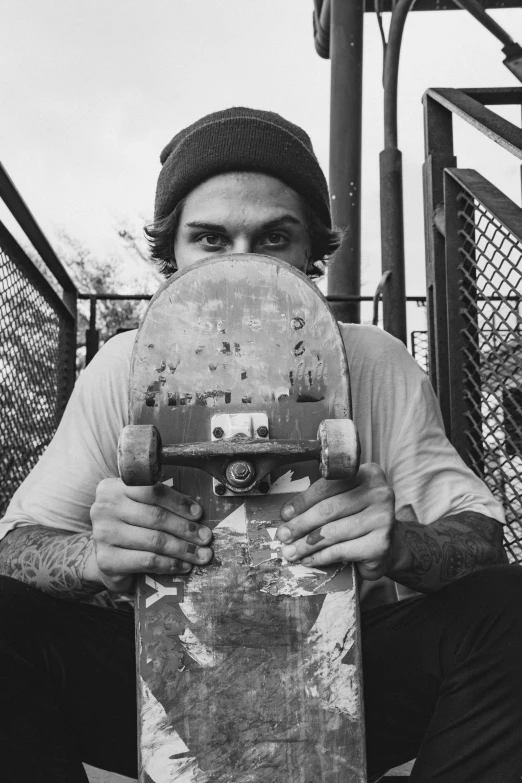 this skateboarder is holding a broken board in one hand