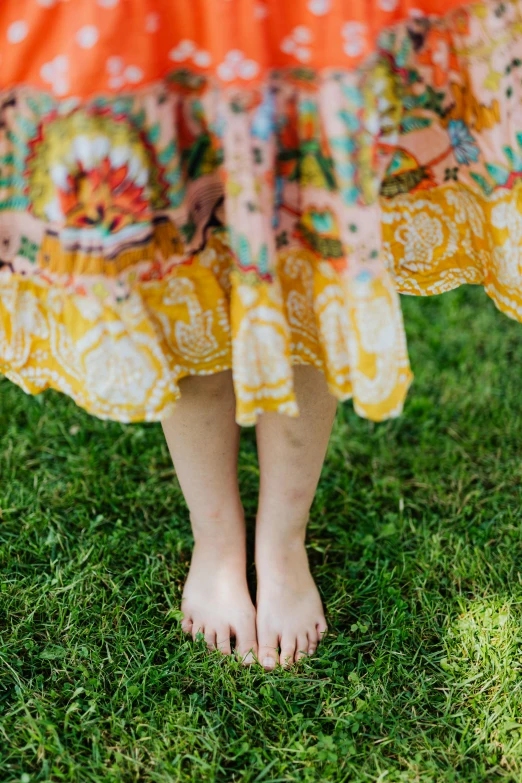 little girl's bare feet in a floral dress