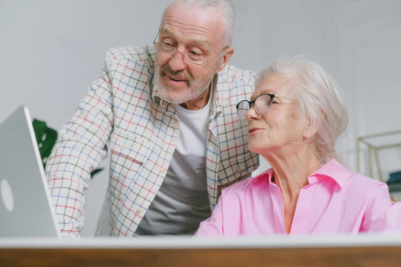 a man looking at an elderly woman on the computer