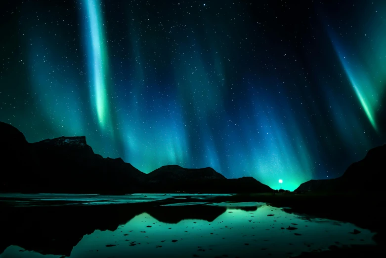this is an auroral display in the sky above some mountains