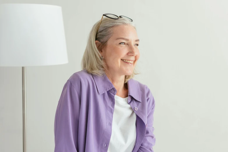 an older woman wearing glasses and a purple shirt