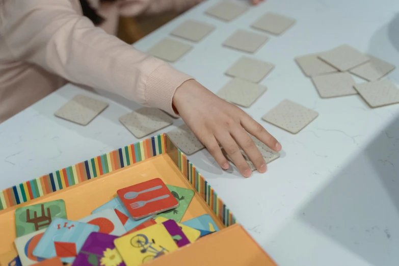 someone's hands with the letters and numbers of alphabets on the table