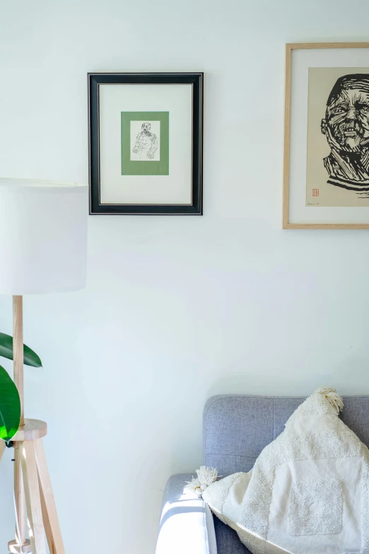 a blue sofa next to a wall with two pictures