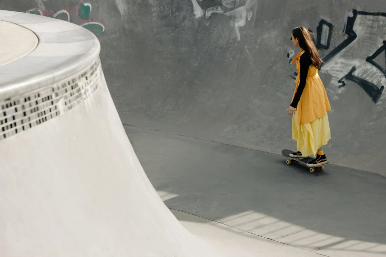 a woman in a long dress riding a skateboard