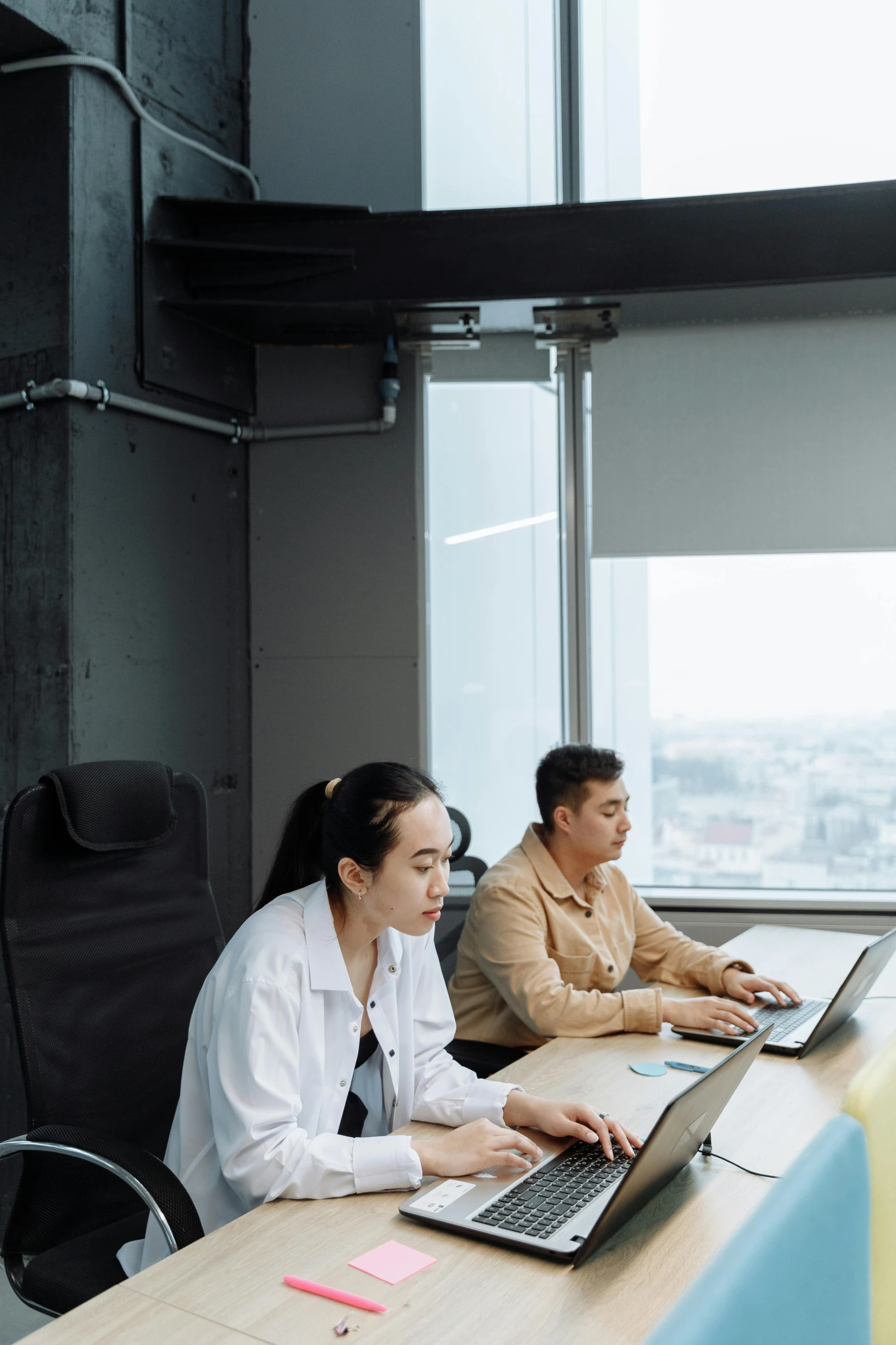 a man and woman using a laptop computers in an office