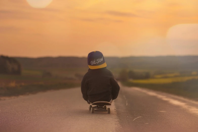 a skateboarder is riding down a country road