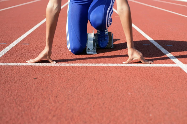 a close up of someone standing at the starting line of a running track