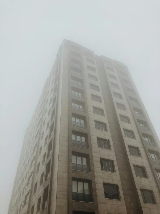 a grey high building has windows on the second floor