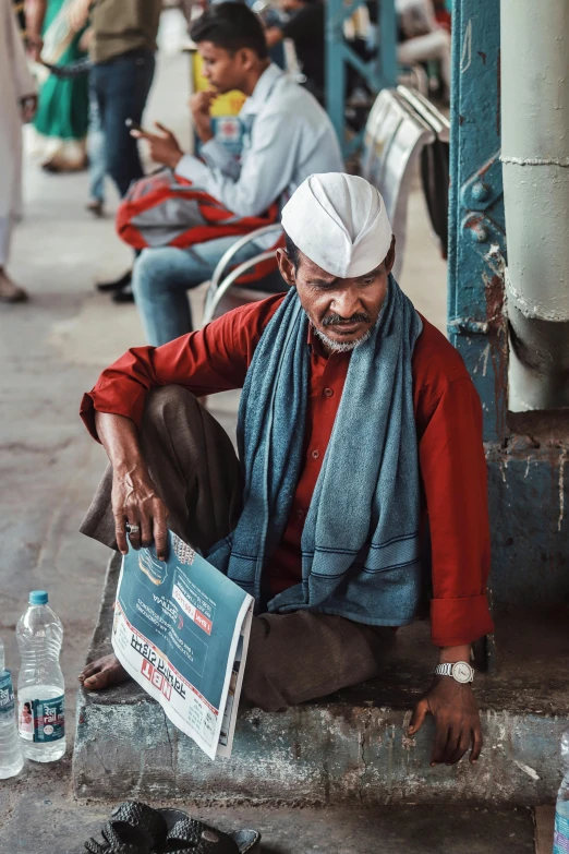 the man with a blue scarf is sitting on the street