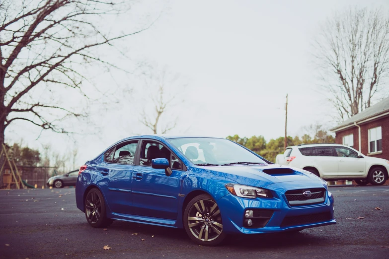 a blue subarunt parked in a parking lot