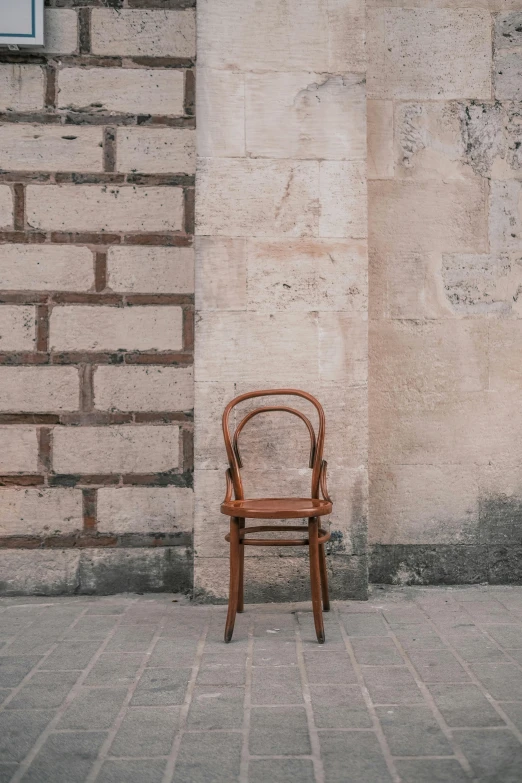 a chair in front of a brick wall