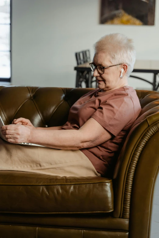 an older woman using a laptop on a couch