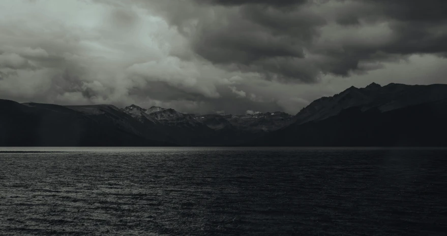 the dark ocean and mountains have dark clouds