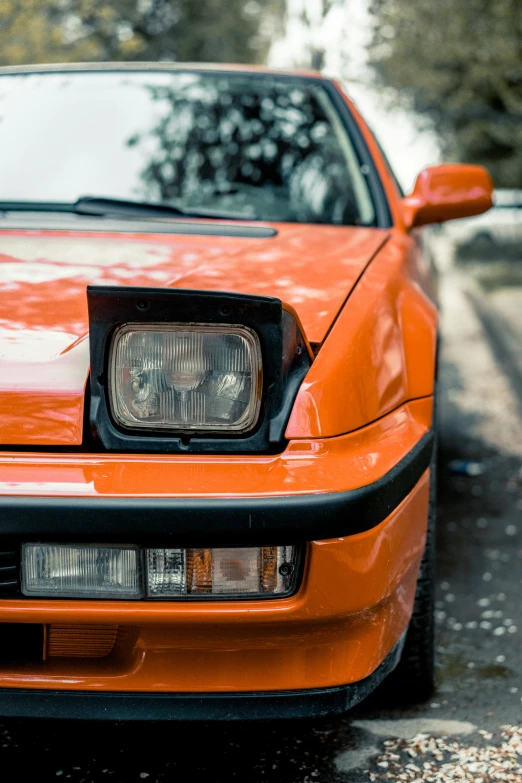 an orange car is parked on the road