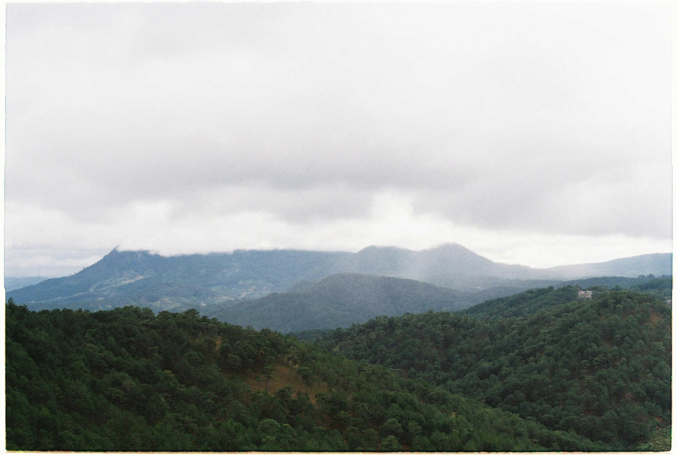 a hill side with mountains in the distance