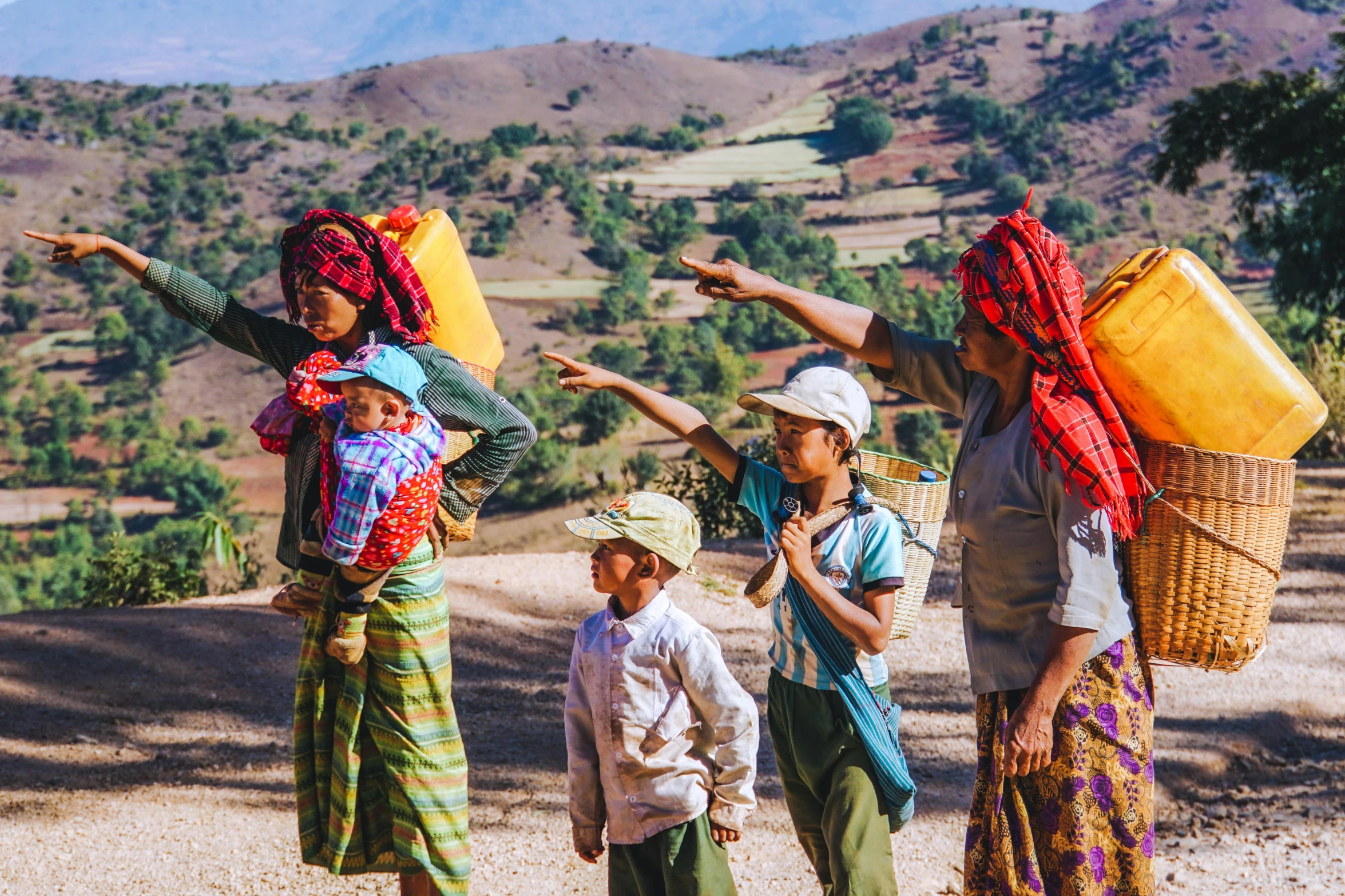 three people with baskets are walking along with their arms spread