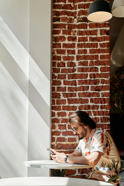 a man seated at a table looking at his phone