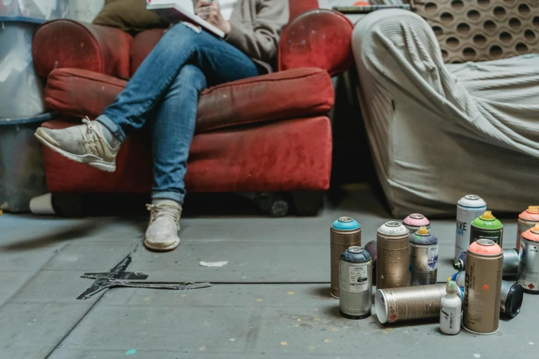 a woman sitting on a couch next to several cans of soda