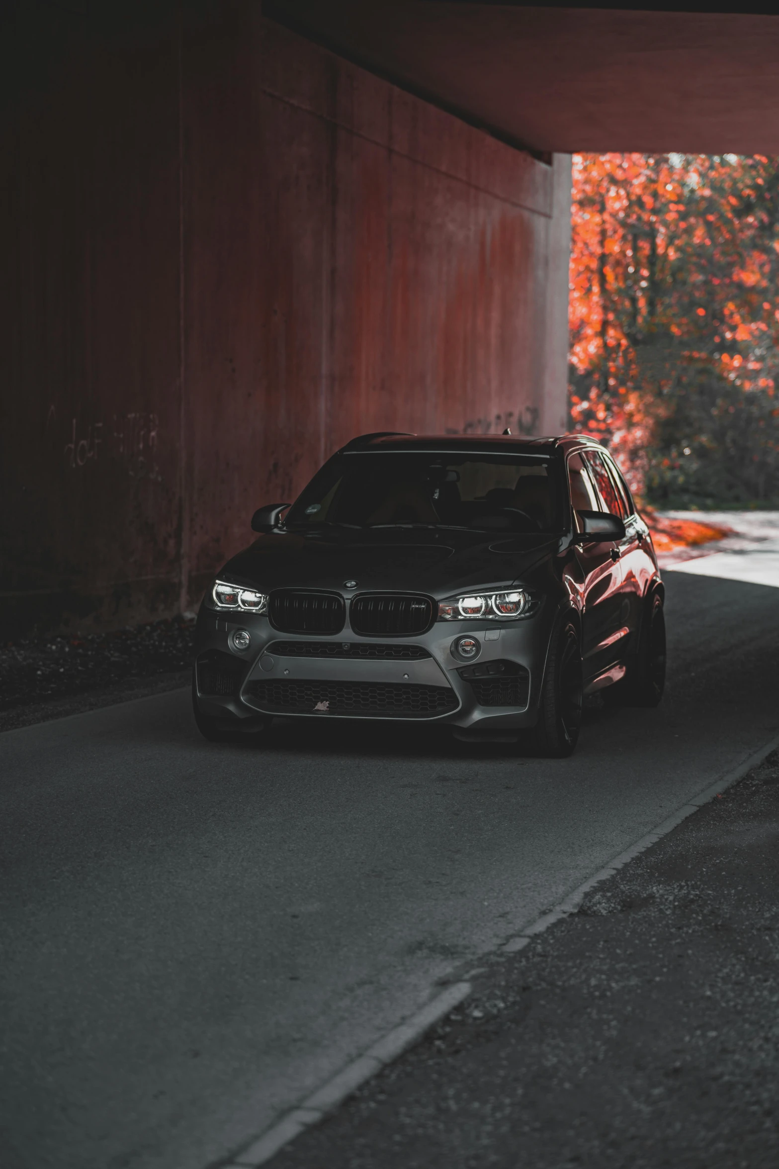 an suv driving on the street by a tunnel