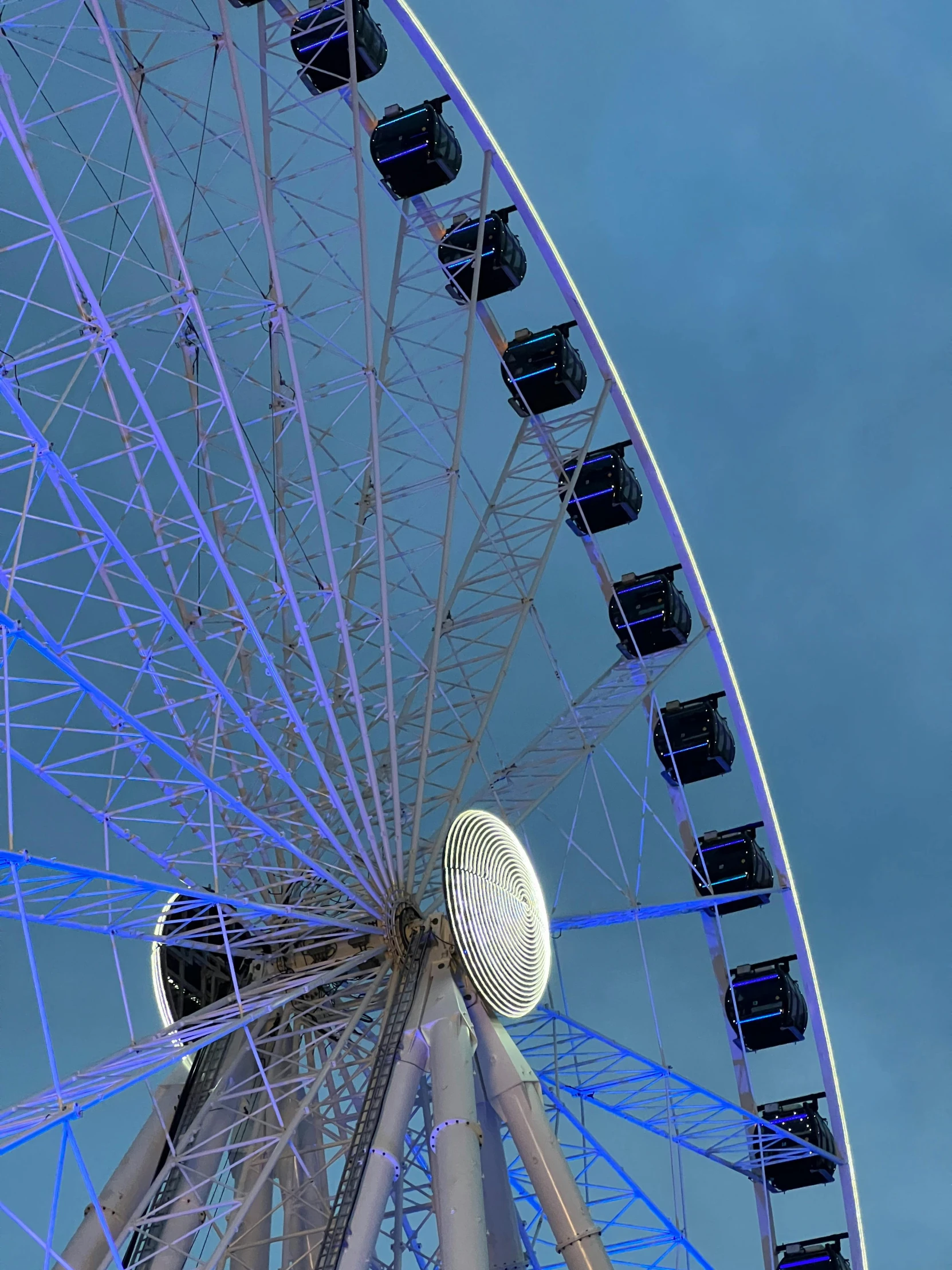 a ferris wheel with multiple lights and a blue sky in the background