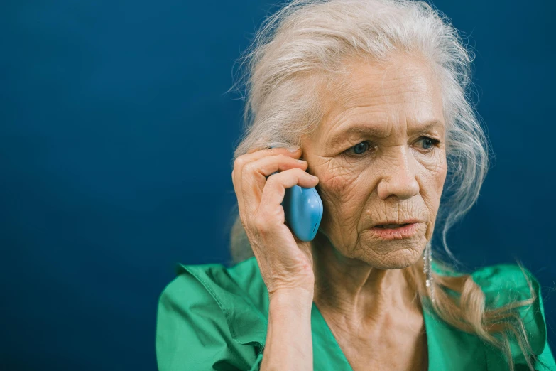 an elderly woman is talking on her phone