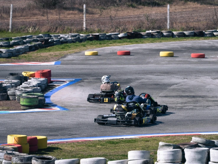 three people racing their go carts on a race track