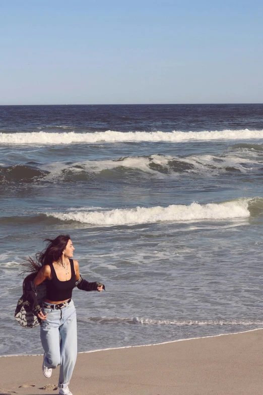 a woman running on the beach by the ocean