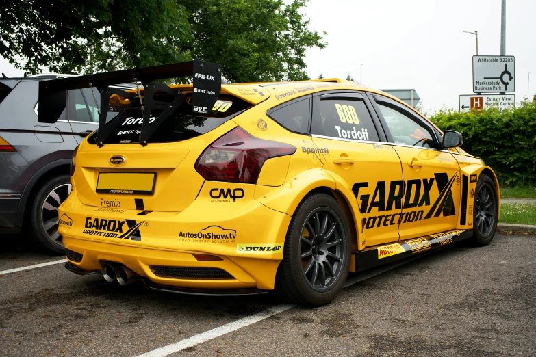 the rear of a yellow car parked on top of the street