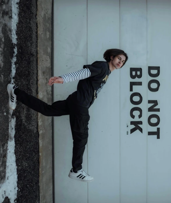 a woman is posing with her  out against the sign