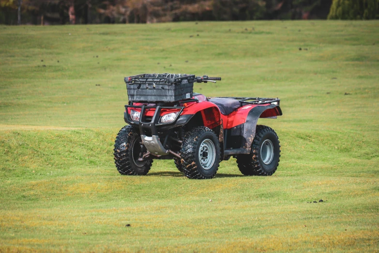 an atv sits on the grass and has no back wheels